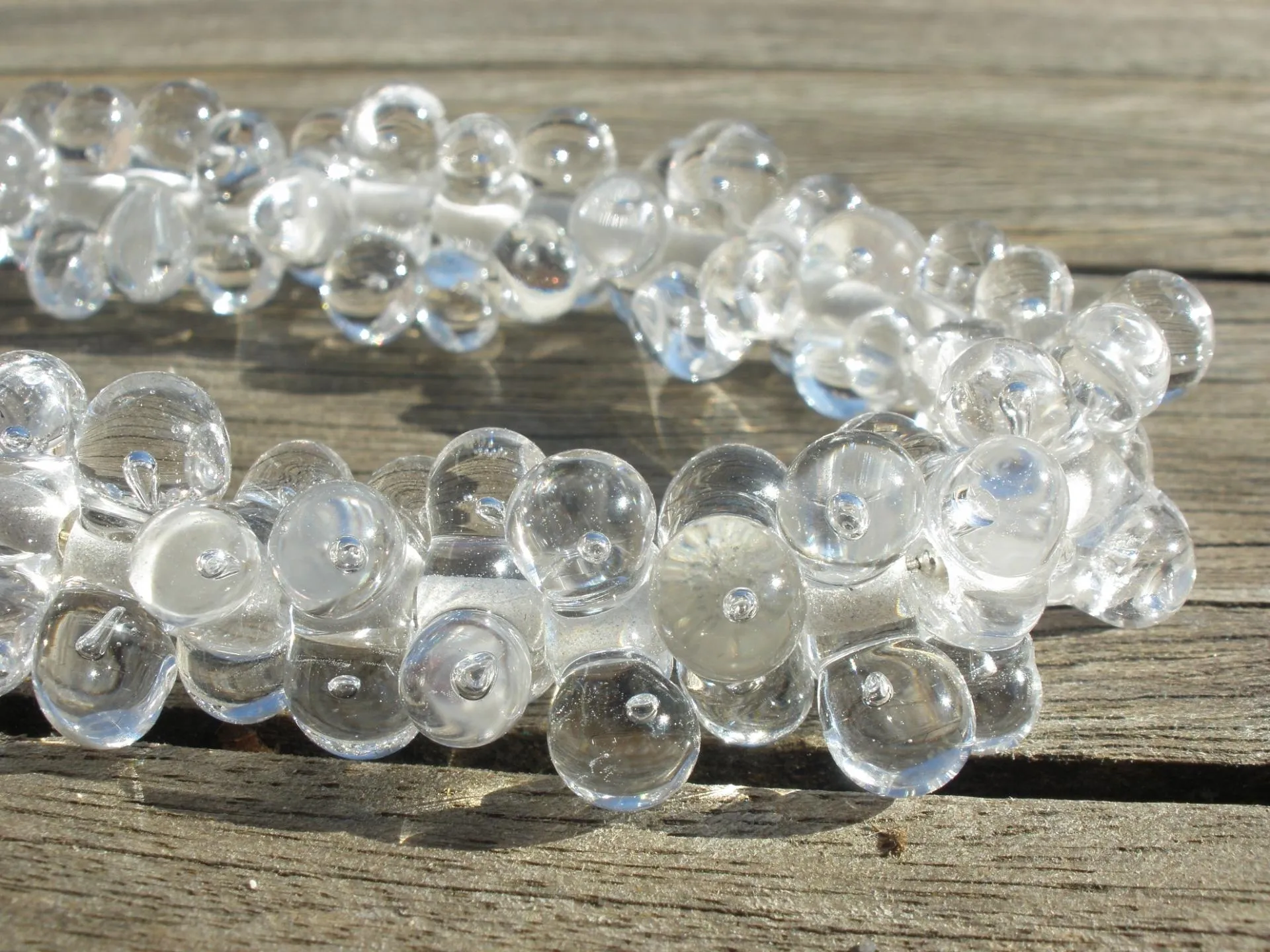 Ketting van heldere glaskralen op een houten tafel